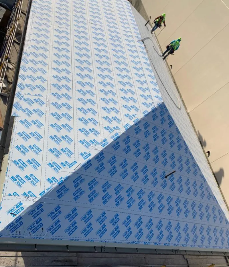 Professional roofers installing underlayment on a metal roof in Peachtree Corners